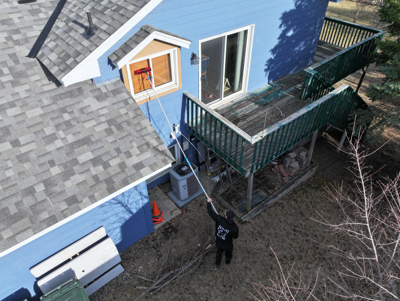 Window technician cleaning exterior panes using professional equipment in Minneapolis