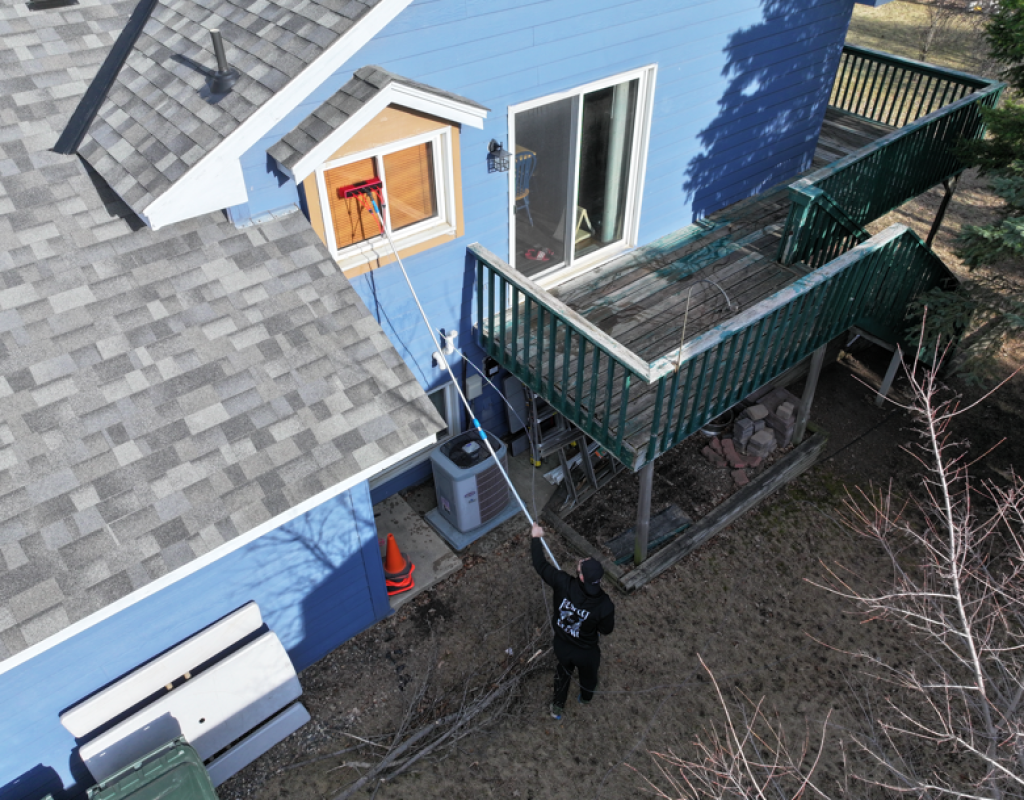 Window technician cleaning exterior panes using professional equipment in Minneapolis